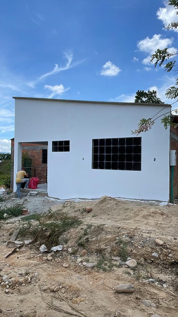 Vista de una casa antes y después de aplicar estuco y pintura. - Después