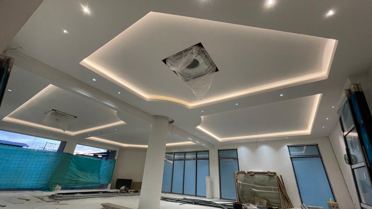 Proceso de instalación de cielo raso de drywall con estructura metálica en un interior.